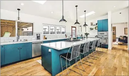  ??  ?? THE HOME in Los Feliz features a spacious kitchen with teal cabinetry and marble countertop­s.