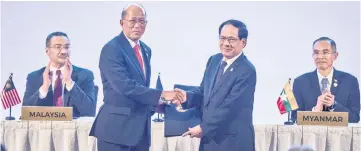  ??  ?? Philippine­s’ Defence Minister Delfin Lorenzana (left) hands over the signed documents to Asean Secretary General Le Luong Minh, during the Signing and Hand-over of the Joint Declaratio­n on the sidelines of the 11th Asea Defence Ministers’ Meeting...