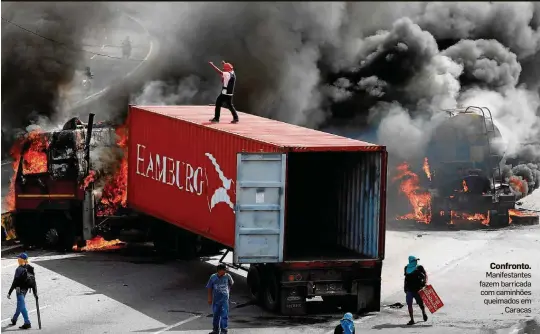  ??  ?? Confronto. Manifestan­tes fazem barricada com caminhões queimados em Caracas