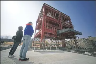  ??  ?? Visitors look at the skeleton of the disaster prevention headquarte­rs building where 43 workers died in Minamisanr­iku.