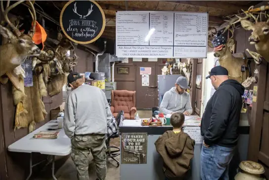  ?? Pittsburgh Post-Gazette photos ?? Josh Davis, an employee at Doug Peffer's Deer Cutting, Smokehouse & Big Game Processing in Ellwood City, helps customers with their orders on Sunday. Pennsylvan­ia’s statewide firearms deer season began Saturday and runs through Dec. 10. Hunting is closed only on Sunday.