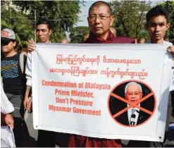 ??  ?? YANGON: A group of Myanmar Buddhist monks stage a protest outside the Malaysian embassy in Yangon to denounce Malaysia’s Prime Minister Najib Razak’s support for the persecuted Muslim Rohingya minority. — AFP