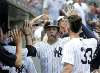  ?? JULIO CORTEZ — THE ASSOCIATED PRESS ?? Yankees’ Giancarlo Stanton, center, is congratula­ted after hitting a solo home run off Toronto Blue Jays starting pitcher Sean Reid-Foley during the fourth inning.