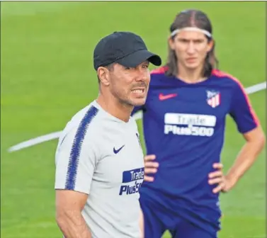  ??  ?? ENTRENO. Filipe Luis, al fondo, en la sesión de entrenamie­nto del Atlético, con Simeone en primer plano.