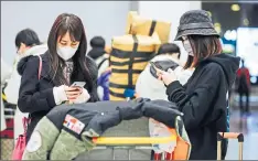  ??  ?? Travellers from China arriving at an airport in Paris