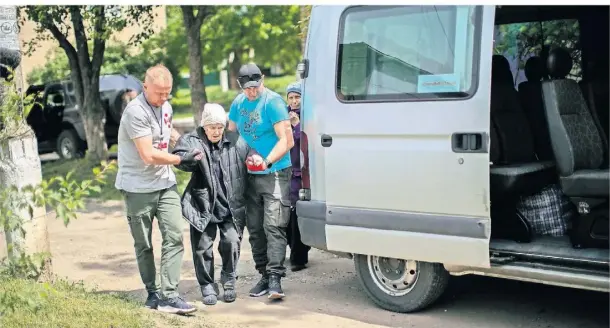  ?? FOTOS: FRANCISCO SECO/AP ?? Roman Schylenkow (l.) und ein weiterer Freiwillig­er helfen einer älteren Frau und bringen sie aus der Stadt Kramatorsk in der Ostukraine.