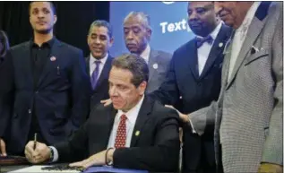  ?? BEBETO MATTHEW — THE ASSOCIATED PRESS ?? New York Gov. Andrew Cuomo, center, surrounded by state and community leaders including juvenile justice activist Akeem Browder, far left, Congressma­n Adriano Espaillat, second from left, the Rev. Al Sharpton, center, State Sen. Jesse Hamilton, second...