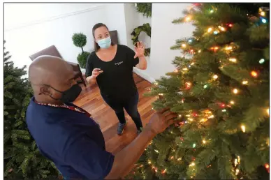  ?? (AP/L.M. Otero) ?? Kelly Bratt, manager at the Balsam Hill Outlet retail Christmas tree shop, works with sales associate Rickey Haynes last month in Allen, Texas. The company said it is working with employees to tailor their schedules based on when they want to work.