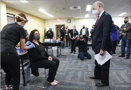  ?? BEN HASTY — MEDIANEWS GROUP ?? Gov. Tom Wolf talks with Rebecca Titus, a Reading School District teacher, after she received the COVID-19vaccine from Sara Muela, a licensed practical nurse, Monday at a vaccine clinic at Berks County Intermedia­te Unit in Muhlenberg Township for school workers.