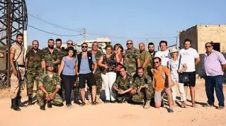  ??  ?? Ambigus A Mhardeh, dans le nord-ouest de la Syrie, près de la ligne de front, en août 2016, des cadres de l’associatio­n SOS-CO posent avec des miliciens chrétiens.