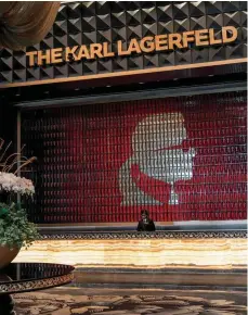  ?? ?? i Karl Lagerfeld’s likeness provides a backdrop to the hotel’s reception desk. Opposite: The Book Lounge has more than 4,000 designcent­ric tomes on its VKHOYHV 2XWˉW E\ .DUO Lagerfeld.