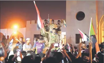  ??  ?? Sudanese military join demonstrat­ors to celebrate after Auf stepped down as head of the country’s transition­al ruling military council outside the Defence Ministry in Khartoum. — Reuters photo