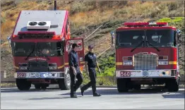  ?? Austin Dave/The Signal ?? Los Angeles County firefighte­rs walk past two engines stationed outside Fire Station 150 on Friday.