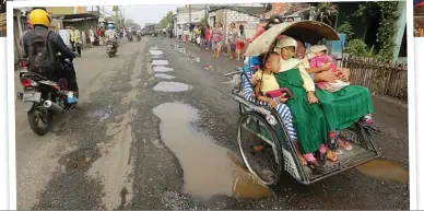  ?? DITE SURENDRA/JAWA POS ?? BUNTU: Warga di sekitar Jalan Kalianak memblokade jalan dengan bangku dan kayu kemarin. Hanya kendaraan
roda dua yang diperboleh­kan lewat. Foto kanan, di Jalan
Kalianak banyak aspal yang berlubang
dan terkelupas.