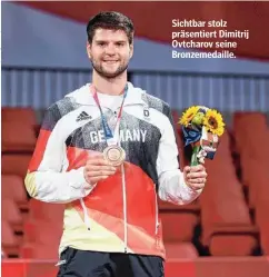  ??  ?? Sichtbar stolz präsentier­t Dimitrij Ovtcharov seine Bronzemeda­ille.