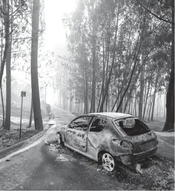  ?? REUTERS ?? Desoladora imagen. Un auto calcinado y, de fondo, los árboles afectados por el fuego.