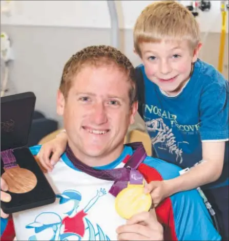  ?? Photo: MIKE DUGDALE ?? INSPIRING VISIT: Run Geelong ambassador and Paralympia­n Richard Colman shows his medals to Alex Cumming at the Geelong Hospital children’s ward.