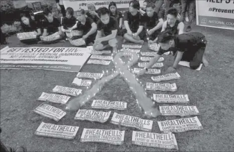  ??  ?? People light candles to mark World AIDS day in Quezon City Thursday.