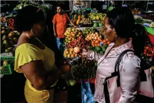  ?? (AFP/Getty) ?? Shoppers in Cali, Colombia last week – the global economy’s growth forecast has been slashed by almost half