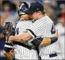  ?? KATHY WILLENS / AP ?? Tommy Kahnle hugs catcher Gary Sanchez after the right-hander earned his first save of the season in the Yankees’ 7-3 win Monday night.