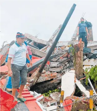 ?? Photo / AP ?? Residents inspect earthquake-damaged houses in Mamuju, West Sulawesi, Indonesia.