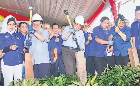  ??  ?? Abang Johari (centre) hammering a piling column to symbolical­ly launch the first 26 units of SPEKTRA houses located some 10km from Lundu Town yesterday together with Uggah (second left) and Rohani (right) in the presence of assistant ministers and...