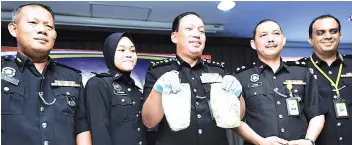  ??  ?? Zaini shows the two packets of syabu seized from the suspected drug trafficker in Sandakan.