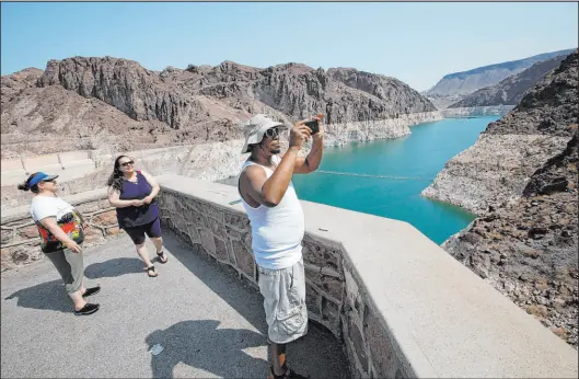  ?? Chitose Suzuki Las Vegas Review-journal @chitosepho­to ?? Eric Bonner of Michigan visits Hoover Dam on Thursday with his mother-in-law, Zina Ibragimova, left, and sister-in-law Gamar Ibragimova. Lake Mead is nearing its first federally declared water shortage as low water levels persist.