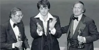  ?? Associated Press ?? HONORS FOR ‘ROCKY’ Robert Chartoff, right, with partner Irwin Winkler, left, and “Rocky” star Sylvester Stallone after re
ceiving Golden Globe awards in 1977. The partners also produced “The Right Stuff.”