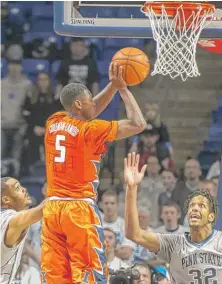  ?? | AP ?? Illinois guard Jalen Coleman- Lands jumps for a shot while Penn State’s Shep Garner ( left) and Jordan Dickerson defend Sunday.