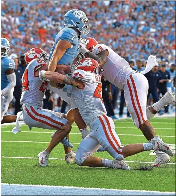  ?? GRANT HALVERSON – GETTY IMAGES ?? From left, Clemson’s Nolan Turner, James Skalski and Xavier Thomas stop Sam Howell of UNC on the two-point try.