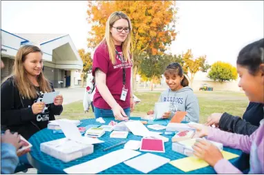  ?? CONTRIBUTE­D PHOTO BY ROBERTO ESCUDERO ?? Jennifer Aquila (center), program specialist for Burton Middle School’s Boys and Girls Club, supervises students as they make thank-you cards for veterans as part of their “Thank You for Your Service — Veterans Card Service Project.”