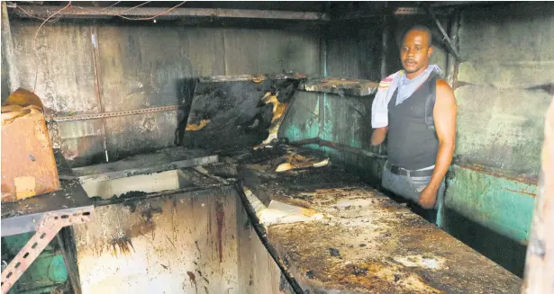  ?? PHOTO BY CHRISTOPHE­R SERJU ?? A dejected Jermaine Wilks stands inside the ruins of the meat mart he operated along with his wife, Dawn, on Monday. The couple lost two well-stocked deep freezers, along with supplies, in a late-night fire on Sunday.