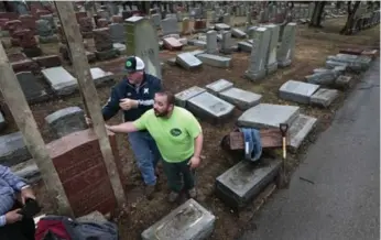  ?? ROBERT COHEN/THE ASSOCIATED PRESS ?? Workers reset toppled headstones in University City, Mo., on Tuesday after more than 170 were vandalized.