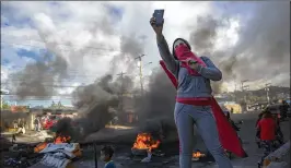 ?? RODRIGO ABD / ASSOCIATED PRESS ?? A supporter of presidenti­al candidate Salvador Nasralla takes a selfie Friday at a roadblock set up by people protesting what they call electoral fraud in Tegucigalp­a, Honduras. Results from the Nov. 26 election are not final.