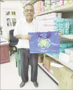  ??  ?? Harry Mattai displays one of the supermarke­t’s reusable shopping bags. The bags, which come in two sizes (the larger one is featured in the photo above) are sold for between $100 and $150.