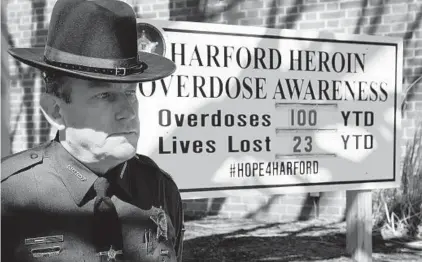  ?? MATT BUTTON/BALTIMORE SUN MEDIA GROUP ?? Harford County Sheriff Jeffrey Gahler stands next to a billboard in March that tallies the county’s heroin overdoses and deaths.