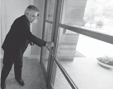  ?? AP PHOTO/LM OTERO ?? Architect Ernesto Miranda locks a door during a tour of his firm’s most recent home project in the enclave of Dallas.