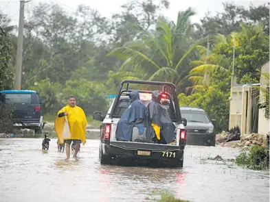  ?? /CORTESÍA SSP-Q.ROO ?? Elementos de la Secretaría de Seguridad Pública de Quintana Roo ayudan a los ciudadanos que se vieron afectados por las lluvias