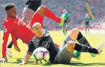  ?? REUTERS ?? Liverpool's Divock Origi (in red) loses balance as he tackles against Southampto­n's Oriol Romeu.