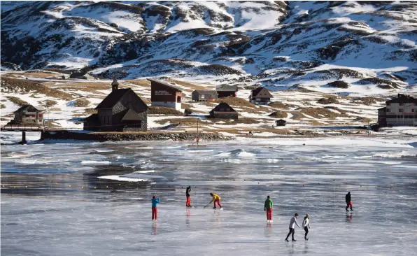  ??  ?? People enjoy ice skating on the black ice of the Melchsee Lake in Melchsee-Frutt, Switzerlan­d yesterday.