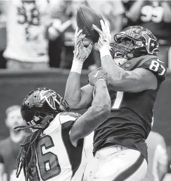  ?? Brett Coomer / Staff photograph­er ?? Texans tight end Darren Fells, right, leaps over Falcons defensive back Kemal Ishmael to haul in one of his two touchdown receptions in Sunday’s win at NRG Stadium.