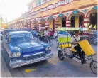  ??  ?? A well-maintained 1950s Oldsmobile shares the road with what are called “bicitaxis” in Holguín, Cuba, a sister city to Santa Fe.