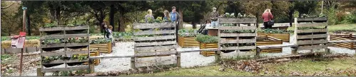  ??  ?? Attendees at an Urban Homesteadi­ng conference in November check out pallet gardens at St. Joseph Center.