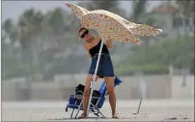  ?? (AP/Wilfredo Lee) ?? A beachgoer fights gusting winds Saturday in Palm Beach, Fla., as Hurricane Isaias makes its way toward the state. Gov. Ron DeSantis declared a state of emergency for Florida’s Atlantic coast and said the state and local communitie­s are opening shelters while taking precaution­s for the coronaviru­s pandemic. Beaches, parks and virus testing sites were ordered closed.
