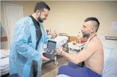  ?? REUTERS ?? Ukraine’s President Volodymyr Zelensky awards an injured Ukrainian service member as he visits a hospital in the Kharkiv region on Wednesday.