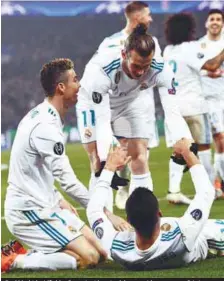 ??  ?? Real Madrid midfielder Casemiro (down) celebrates with teammates Cristiano Ronaldo (left) and Gareth Bale (up) after scoring his team’s second goal during the yesterday’s Champions League match against Paris Saint-Germain. –