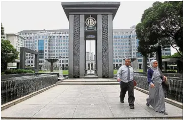  ??  ?? Weak currency: People walk in the courtyard of Bank Indonesia in Jakarta. The rupiah touched 13,905 per US dollar yesterday, a fresh two-year low.