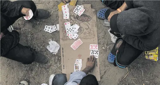  ?? Picture: AFP ?? Central American migrants heading to the US in hopes of a better life, play cards at a shelter in Tijuana, Mexico, near the border with the US. President Donald Trump has sent about 5 800 troops to the border.