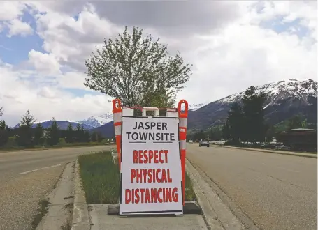  ?? PHOTOS: LARRY WONG ?? A sign at the entrance of the main street in downtown Jasper reminds visitors of the global COVID-19 pandemic. Jasper National Park may have reopened on June 1, but in the nearby Jasper townsite, the drop in tourism due to the COVID pandemic has been a huge blow.